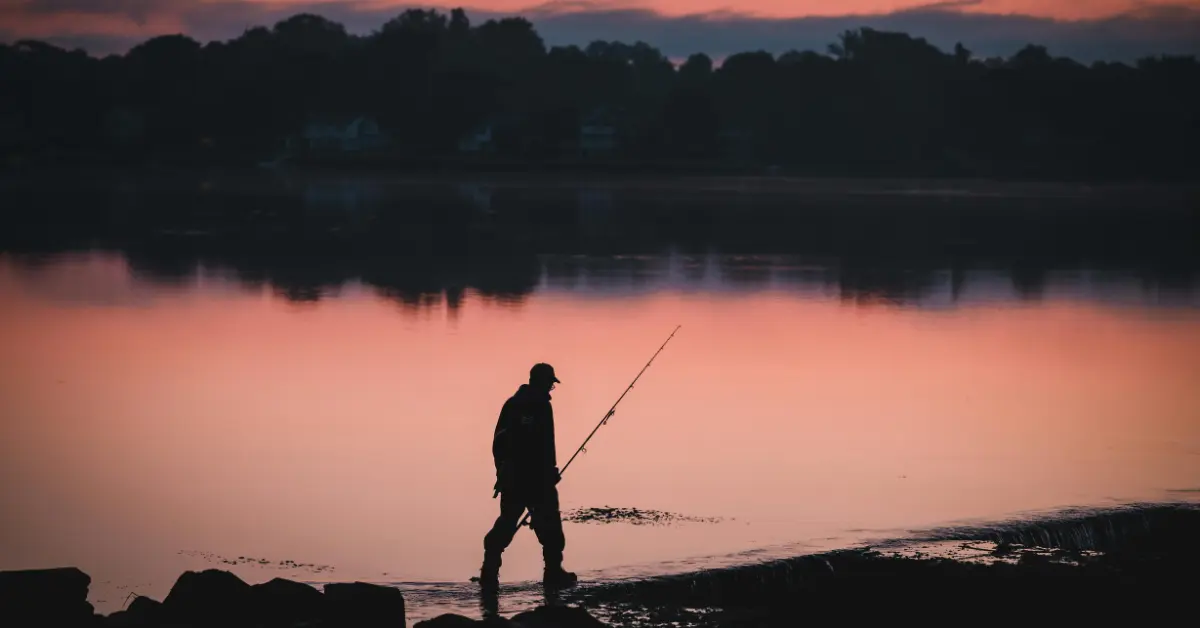Fisher walking by the sea at dawn