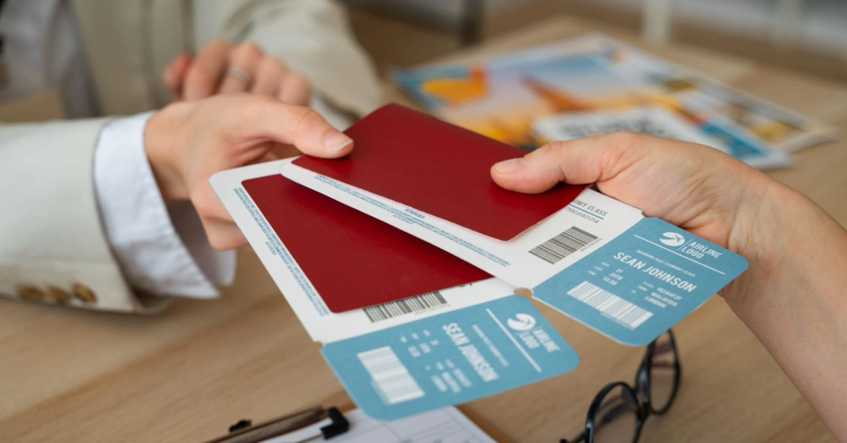 A female travel agent handing a passport and tickets to her customer.