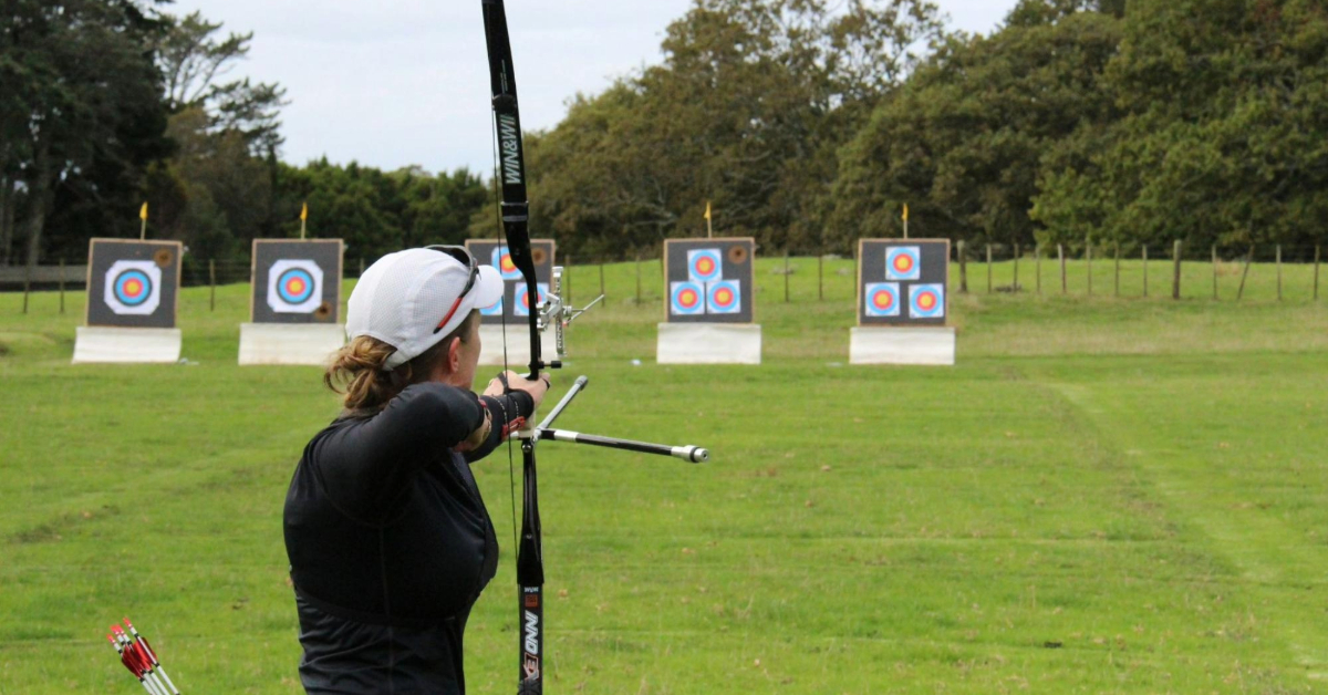 An archery coach taking her shot