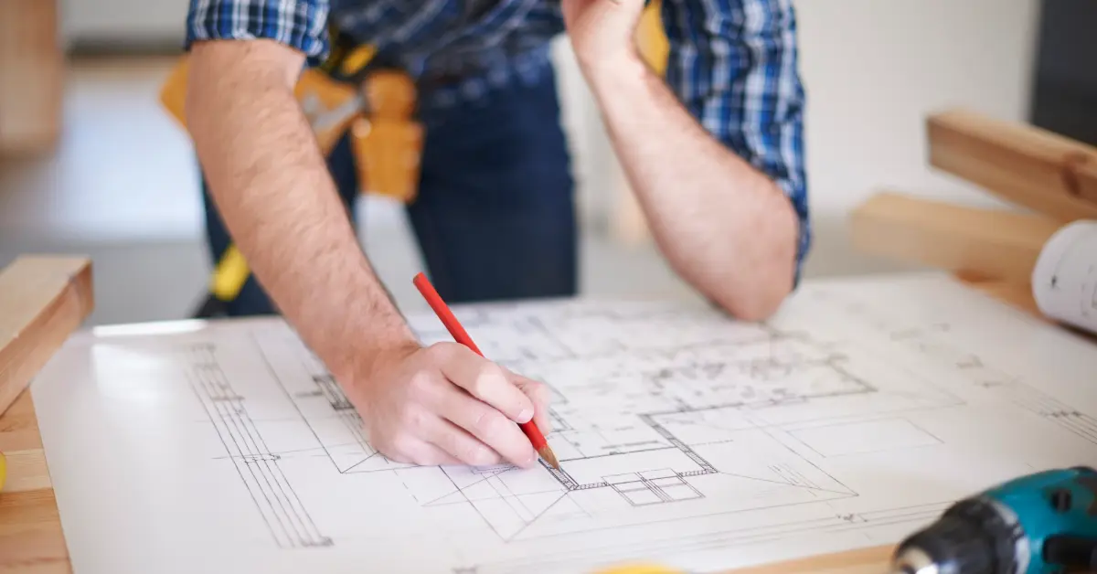 Worker with amendments on blueprint of house
