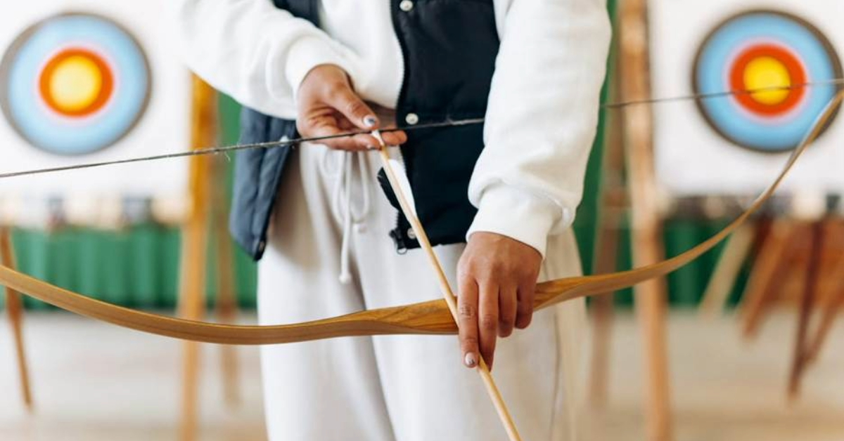 A person getting their bow to practice in the archery club