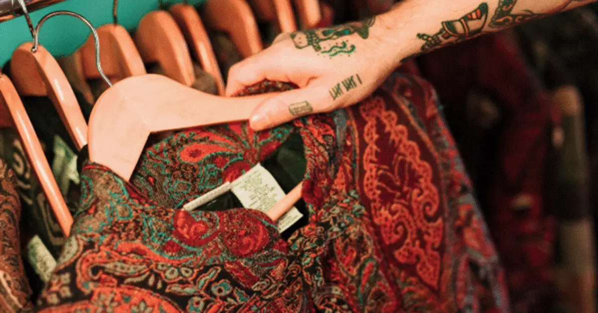 A person picking out an embroidered outfit from a Pakistani clothes shop in Dubai