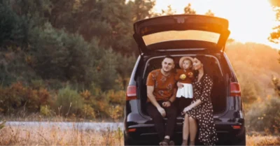 A family sitting in the back of their car while doing road trips from Abu Dhabi