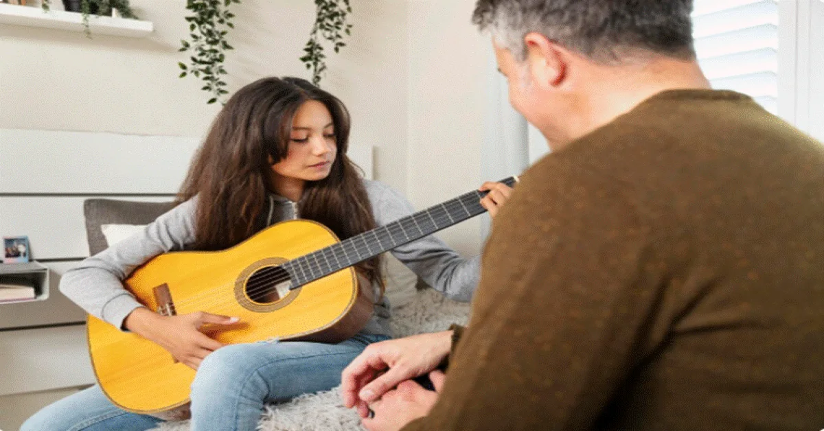 A teacher instructing a student in a guitar class in Abu Dhabi