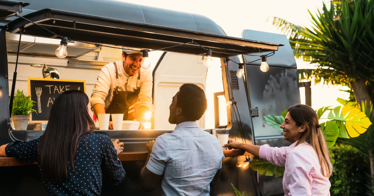  people buying a meal from a food truck near Kite Beach