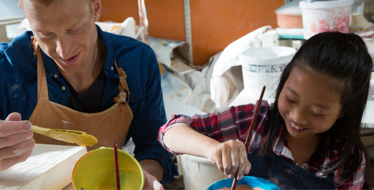 Potter and a little girl are painting a bowl