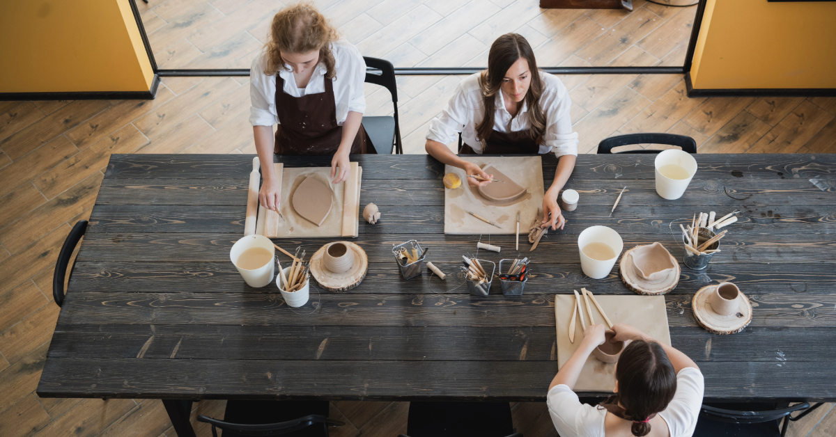 Top view of female artists sculpting different clay products
