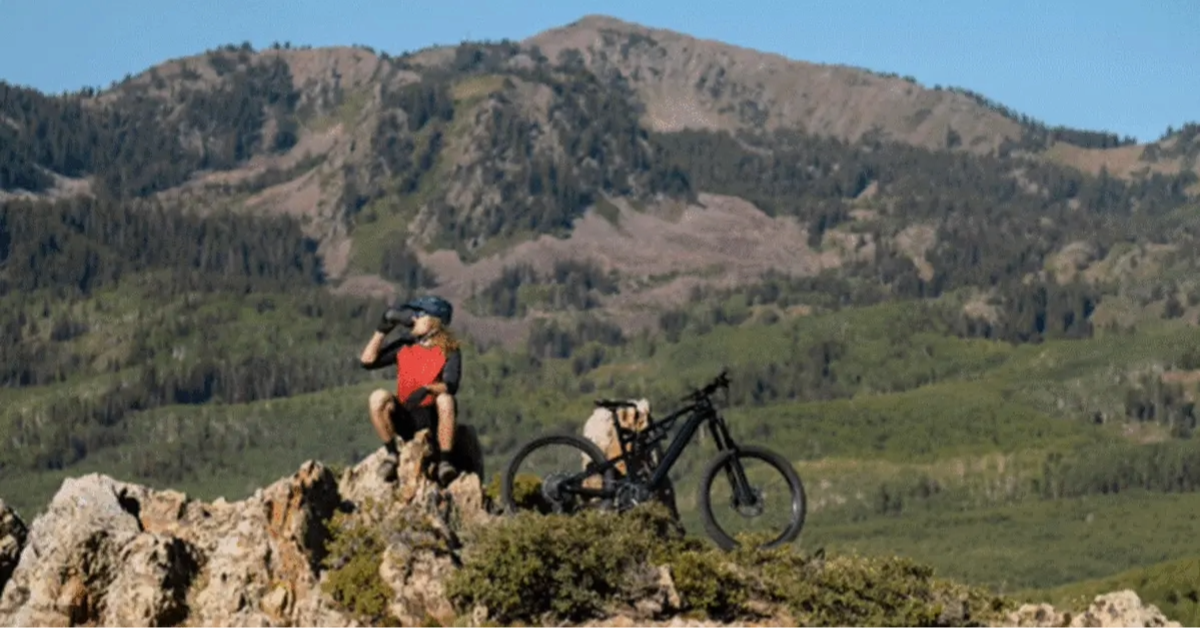 A person resting and drinking water in the Dubai bike trail