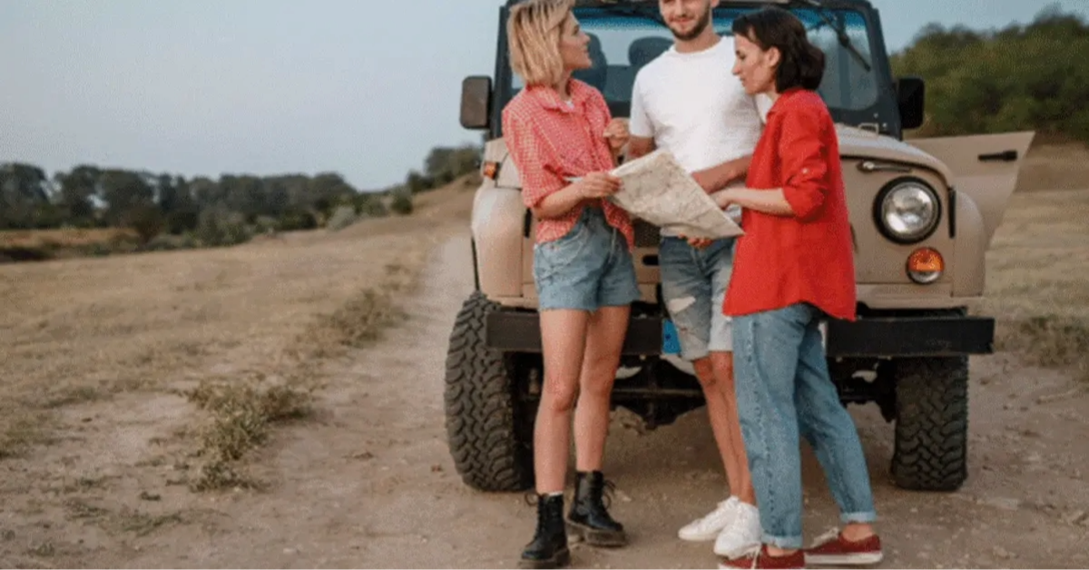 A group of friends consulting a map during their road trip from Abu Dhabi