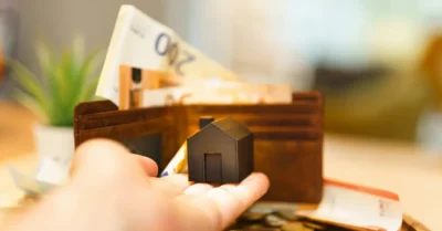 small house with coins and banknotes