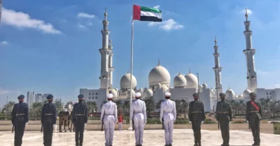 police officers saluting the UAE flag in Sharjah