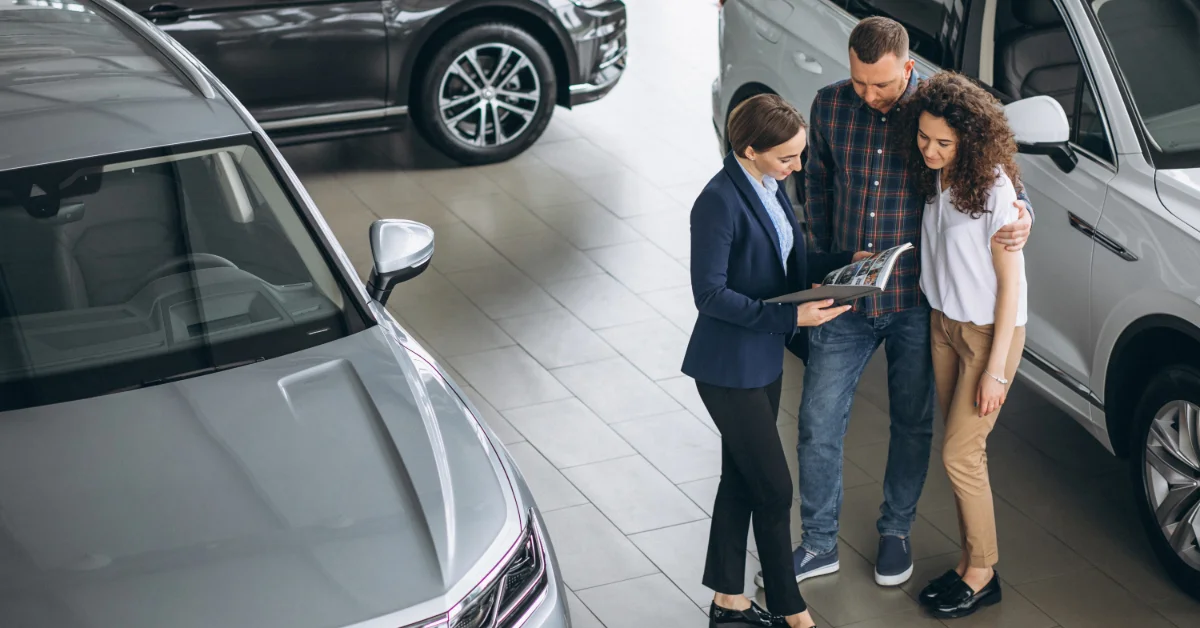 A couple talking to a sales agent in a Sharjah automobile showroom