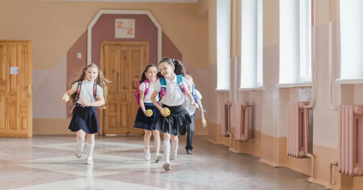 أطفال يركضون بسعادة داخل ممر مدرسي مشرق