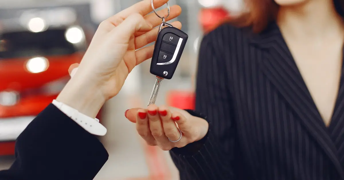 بائع يسلم مفاتيح السيارة للعميل
