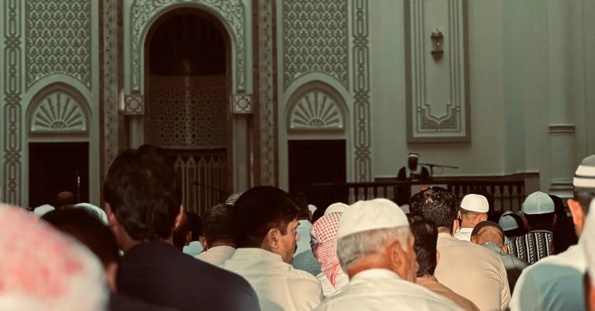 مجموعة من المصلين يؤدون الصلاة في مسجد أمام النوافذ