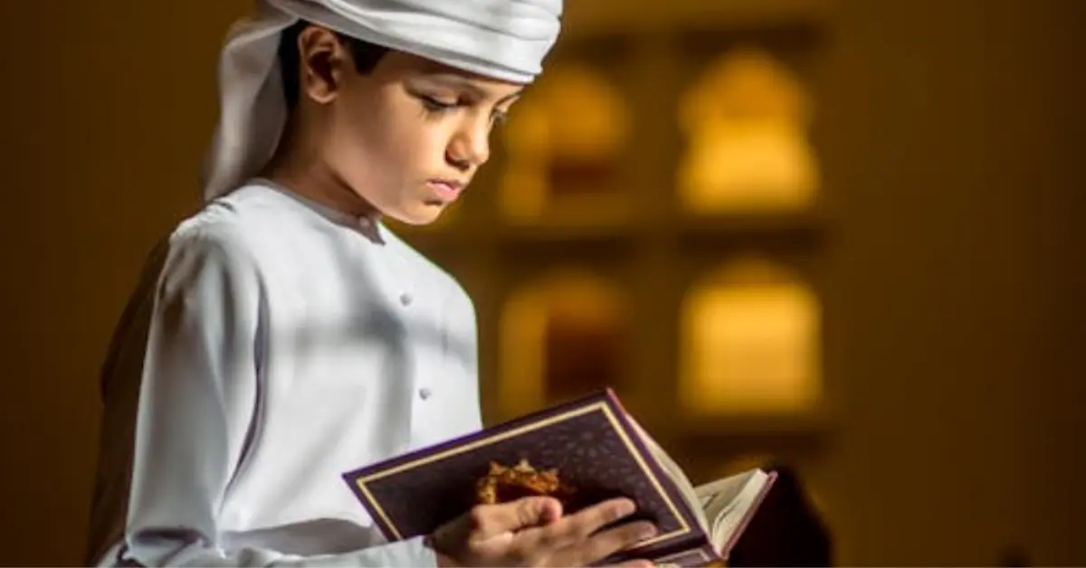 A Boy Sitting in a Mosque and Reading Quran