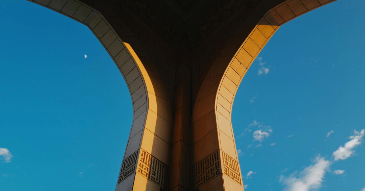 Stone Arches of a Mosque Framed Against a Clear Blue Sky