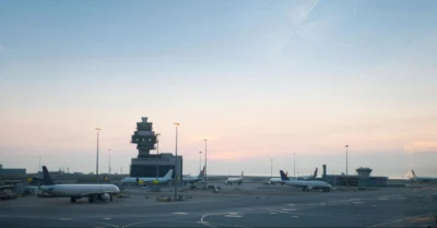 A clear view of an airport runway with airplanes positioned on it