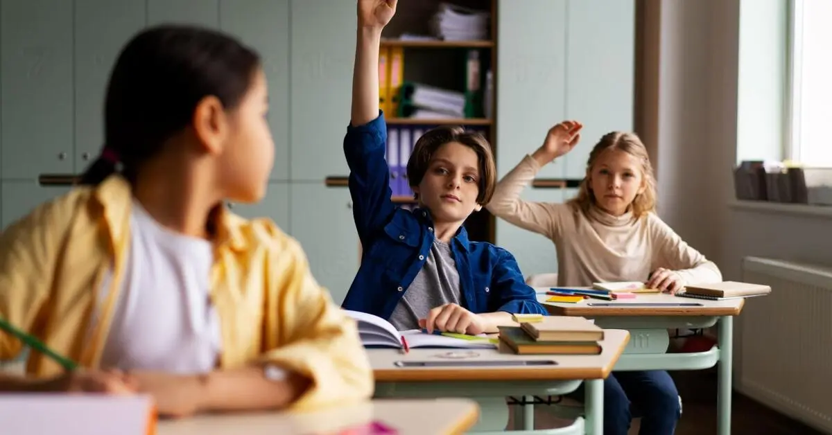 A boy confidently raising his hand, followed by a fellow classmate