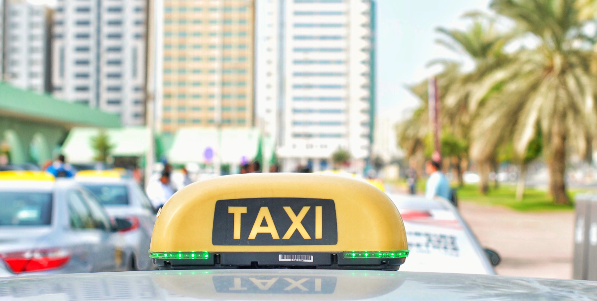 taxi with illuminated roof sign on a city street
