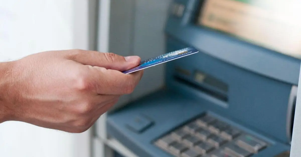 A man inserting his card into the ATM