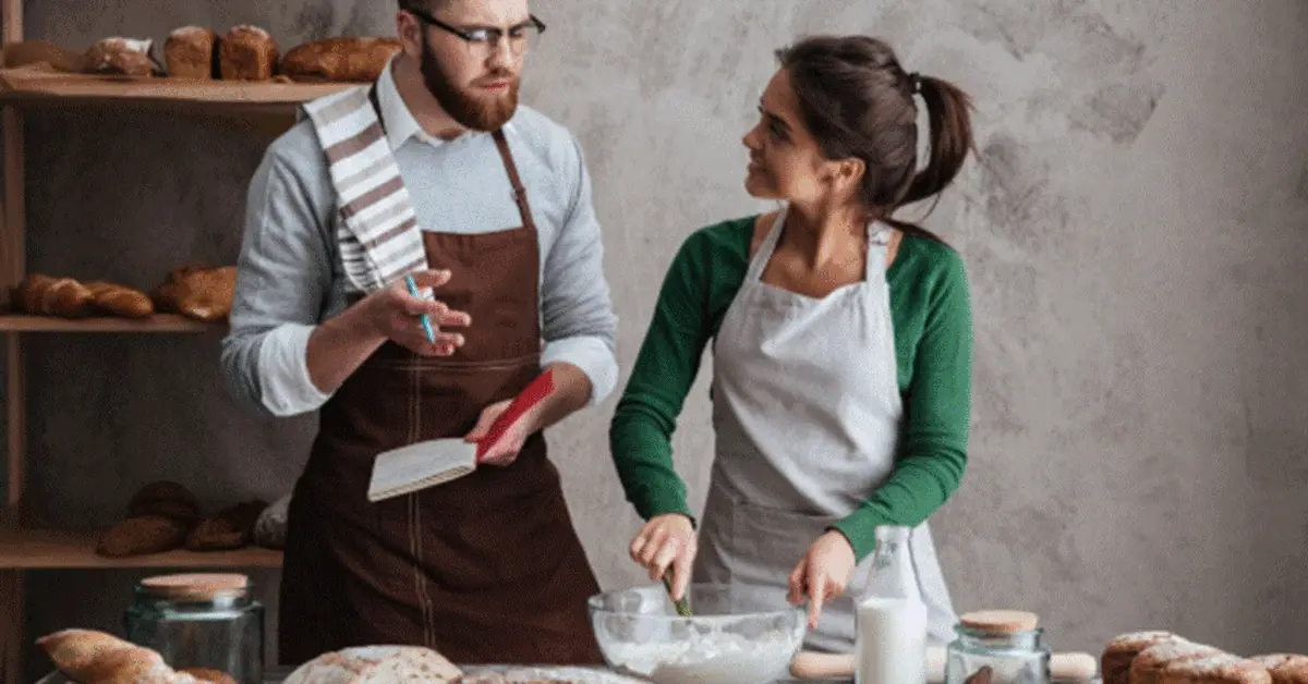 A chef instructing a student in a baking class in Sharjah