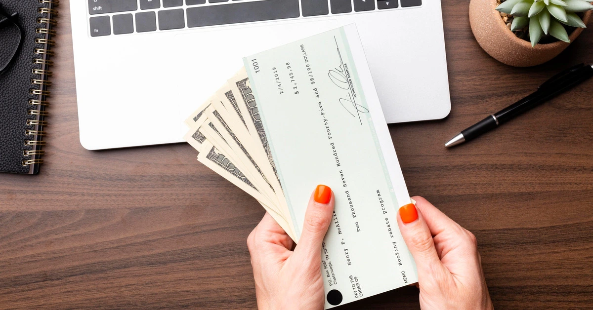 Close up hands holding cash and check