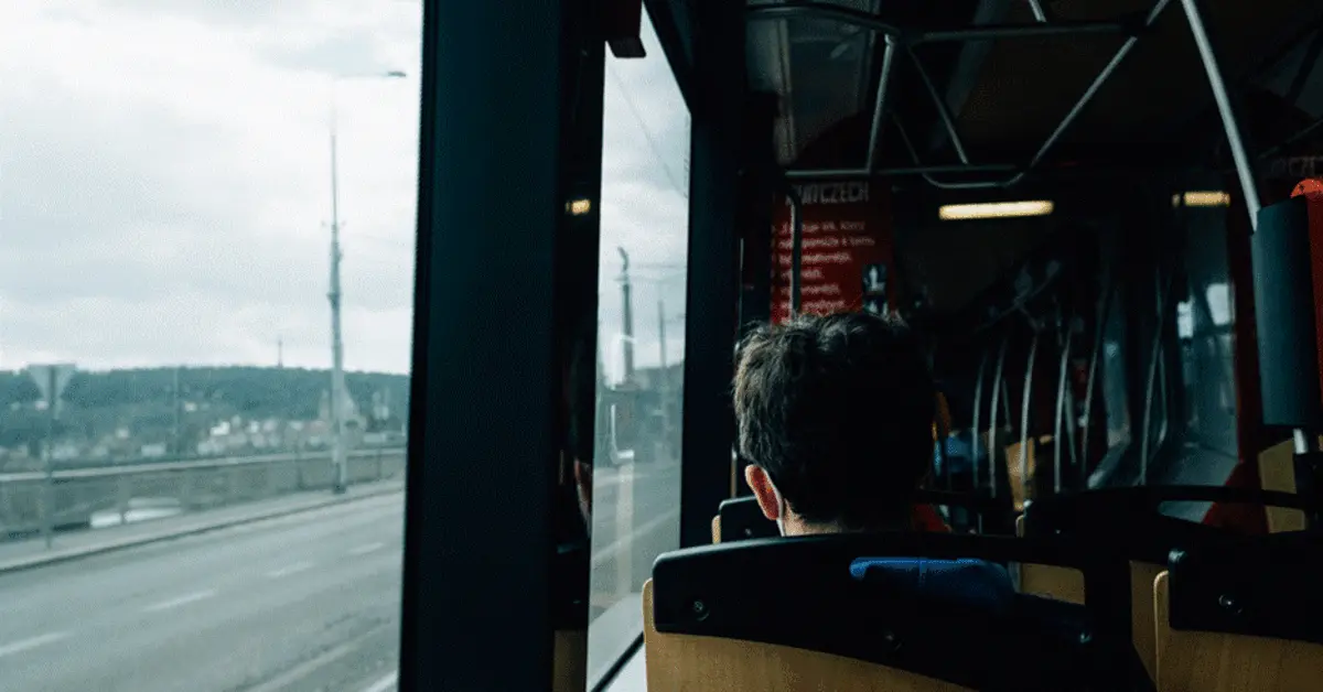 A man looking outside from inside a bus