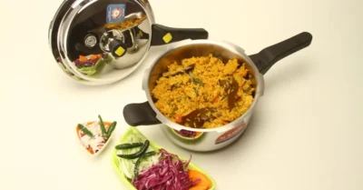 A plate of biryani served with decorative leaves on the table