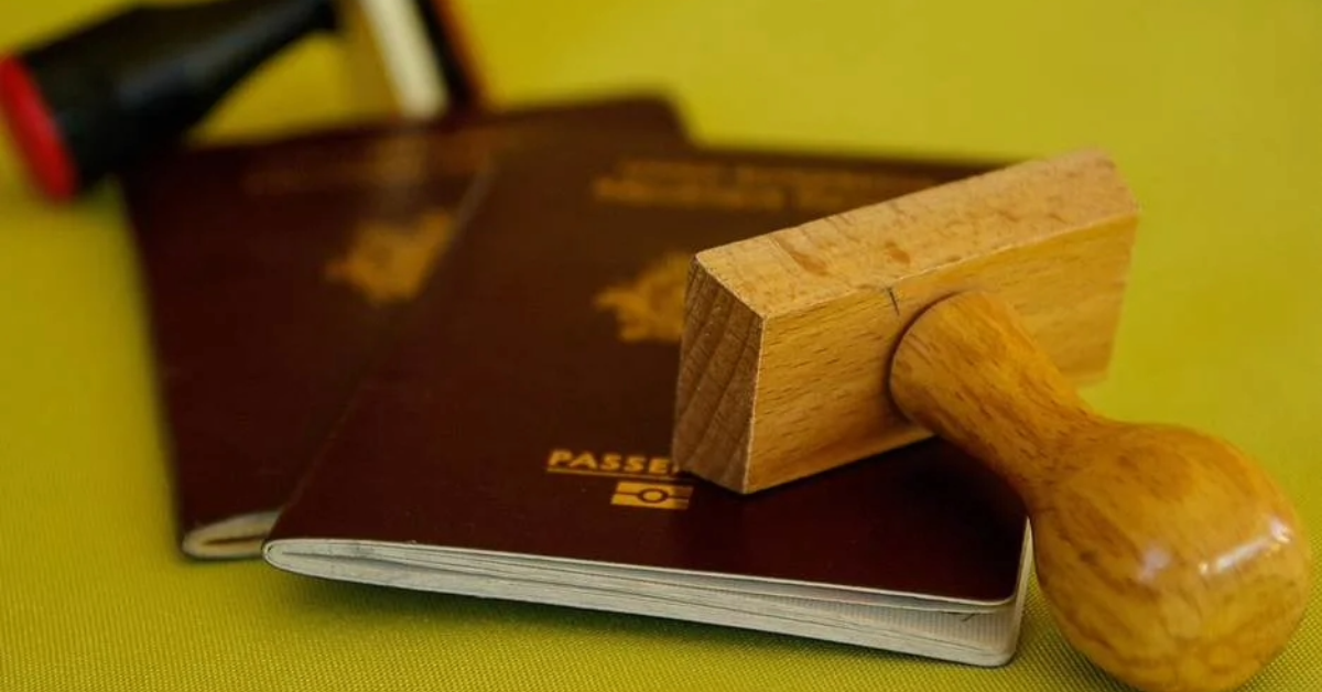 A passport and visa in a table alongside stamps