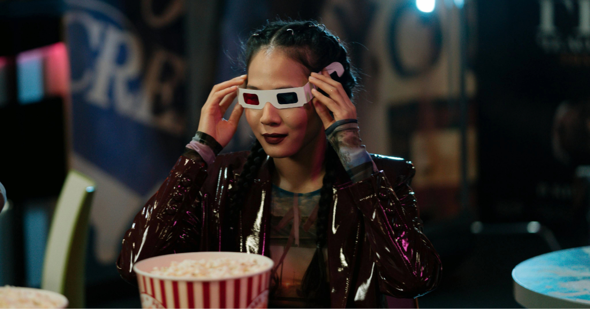 A woman getting ready with popcorn to watch a 3D movie in an IMAX cinema