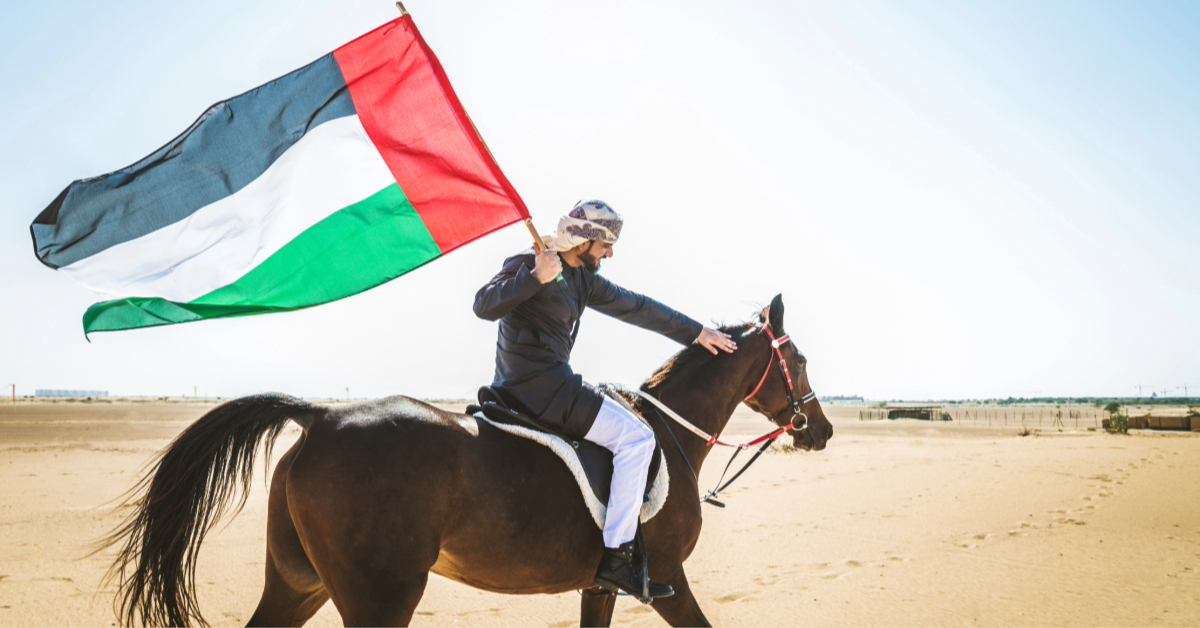 a man riding Arabian horse in Dubai with the UAE flag