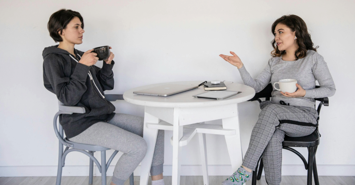 Two women enjoying coffee while talking in a private member club
