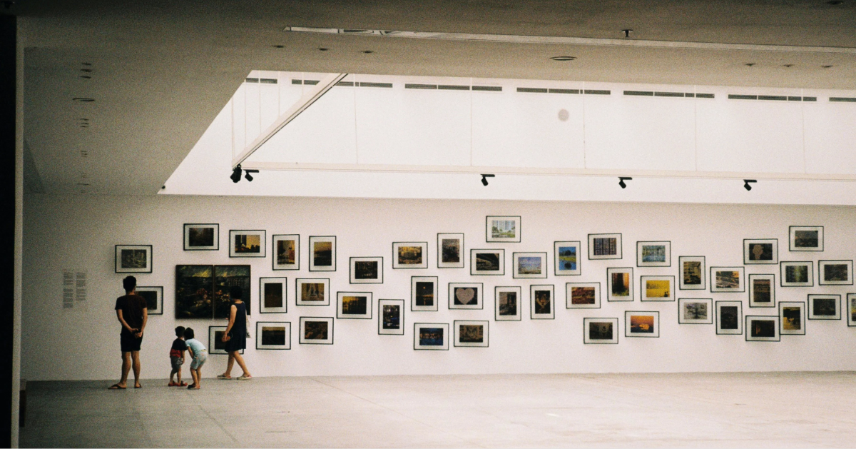 A family checking out a series of paintings on the museum wall