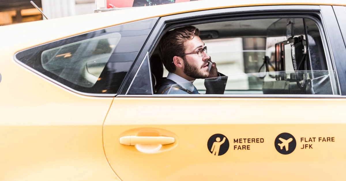 A businessman in a taxi talking on the phone