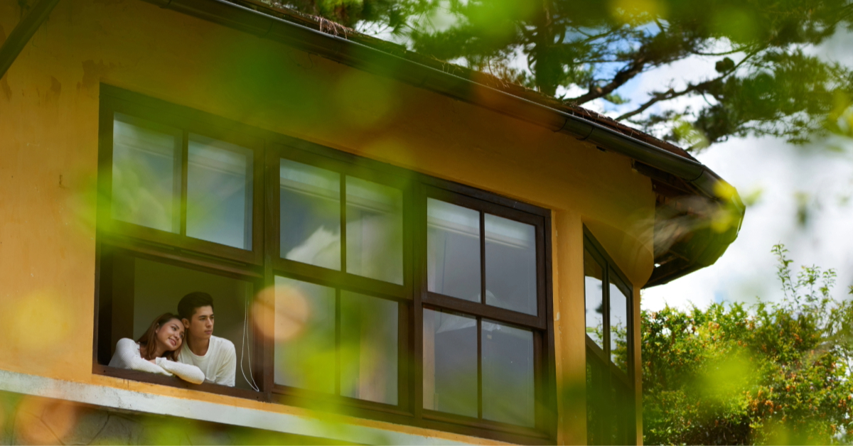 A couple enjoying the breeze by their open window
