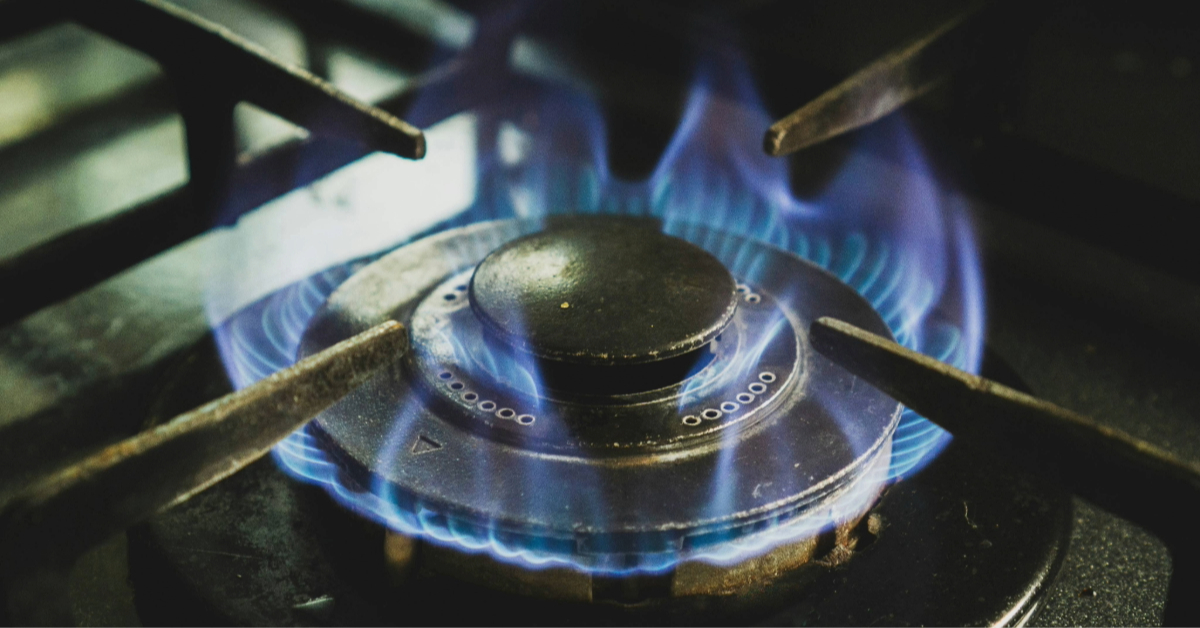 A close-up shot of a gas burner producing a blue flame.