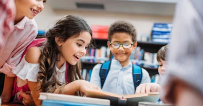 little children looking at a book in the library