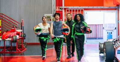 Young adult friends in racing suits in Ferrari world