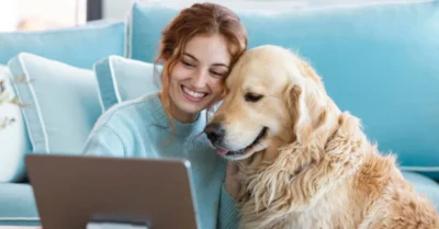 A woman completing her pet registration online with her dog