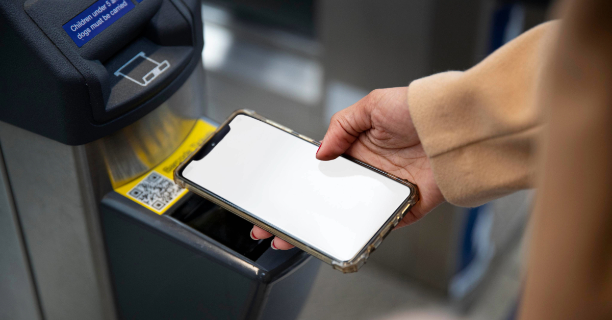A woman tapping her phone on a reader