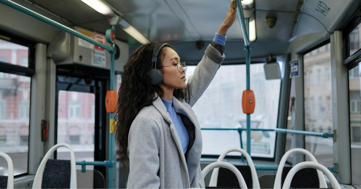 A woman wearing headphones standing inside the F20 bus