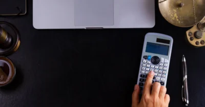 A man using a calculator to calculate his DEWA bills