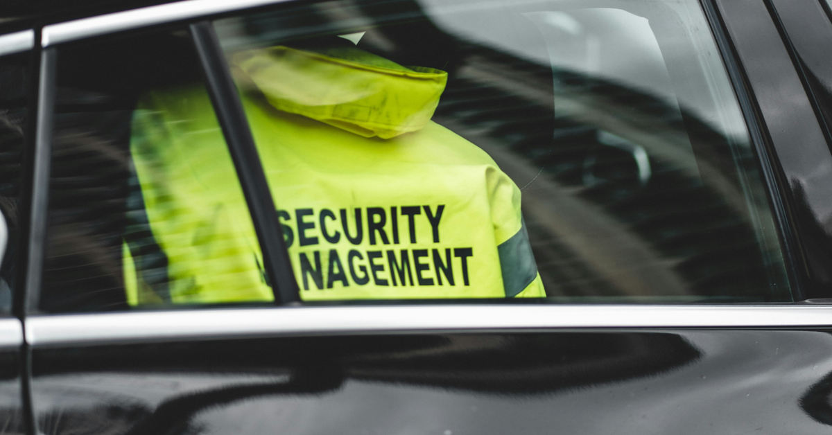 A yellow jacket with “Security Management” written on it, hanging inside a car