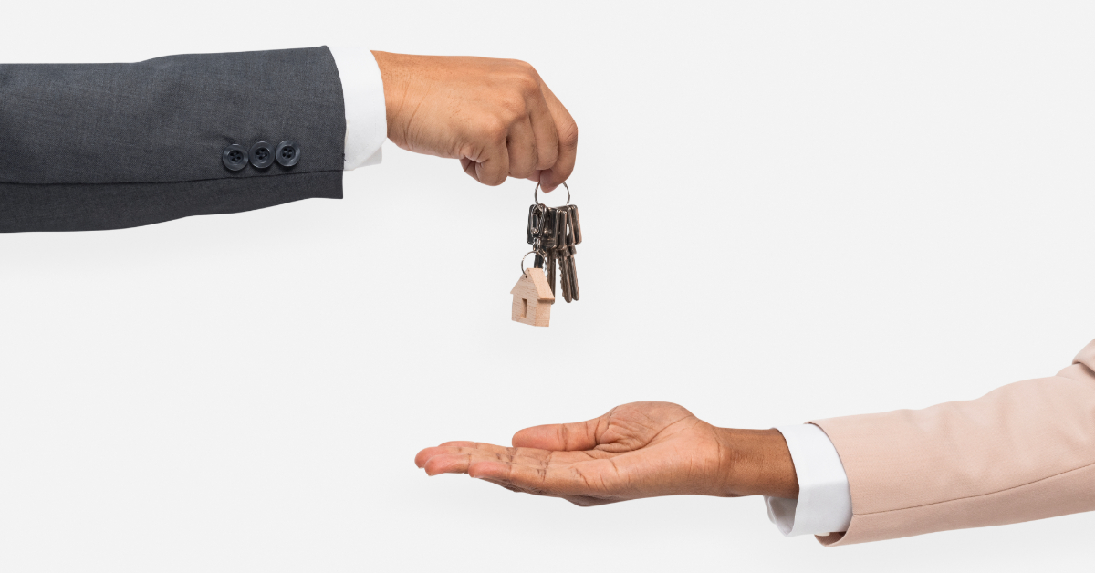 A man handing house keys to a woman