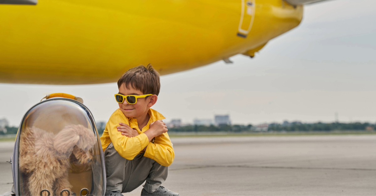 Child seated near his poodle on the runway