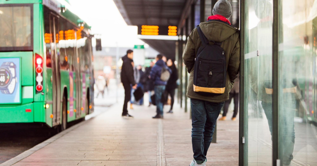 Commuter walking at a bus station on a cloudy day