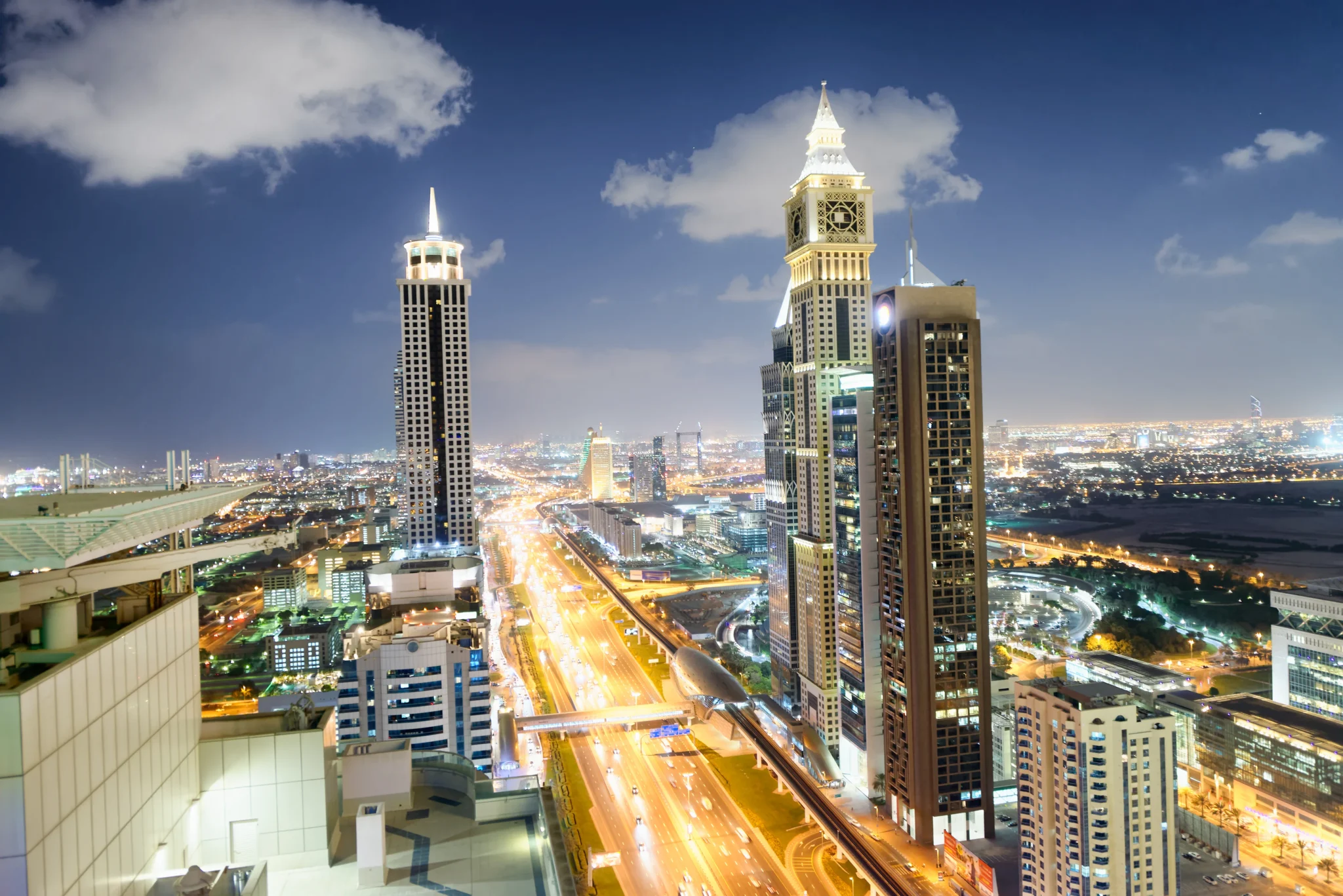 Skyscrapers lighting up at night in Dubai highroads