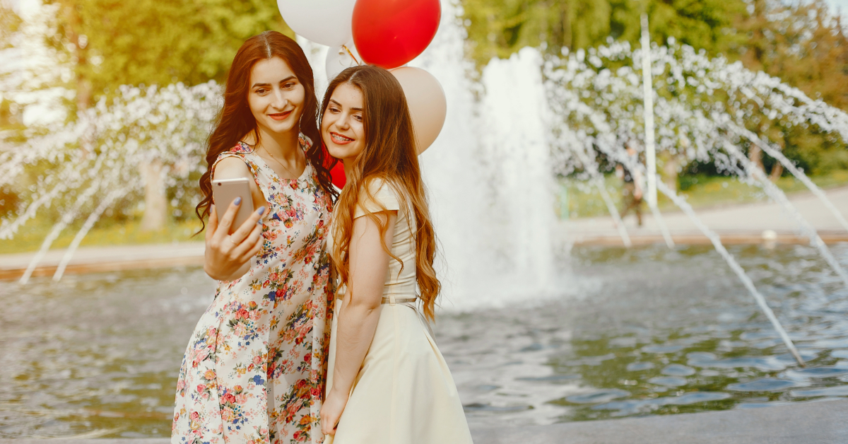 Two friends clicking pictures in front of the fountain in Al Majaz Park in Sharjah
