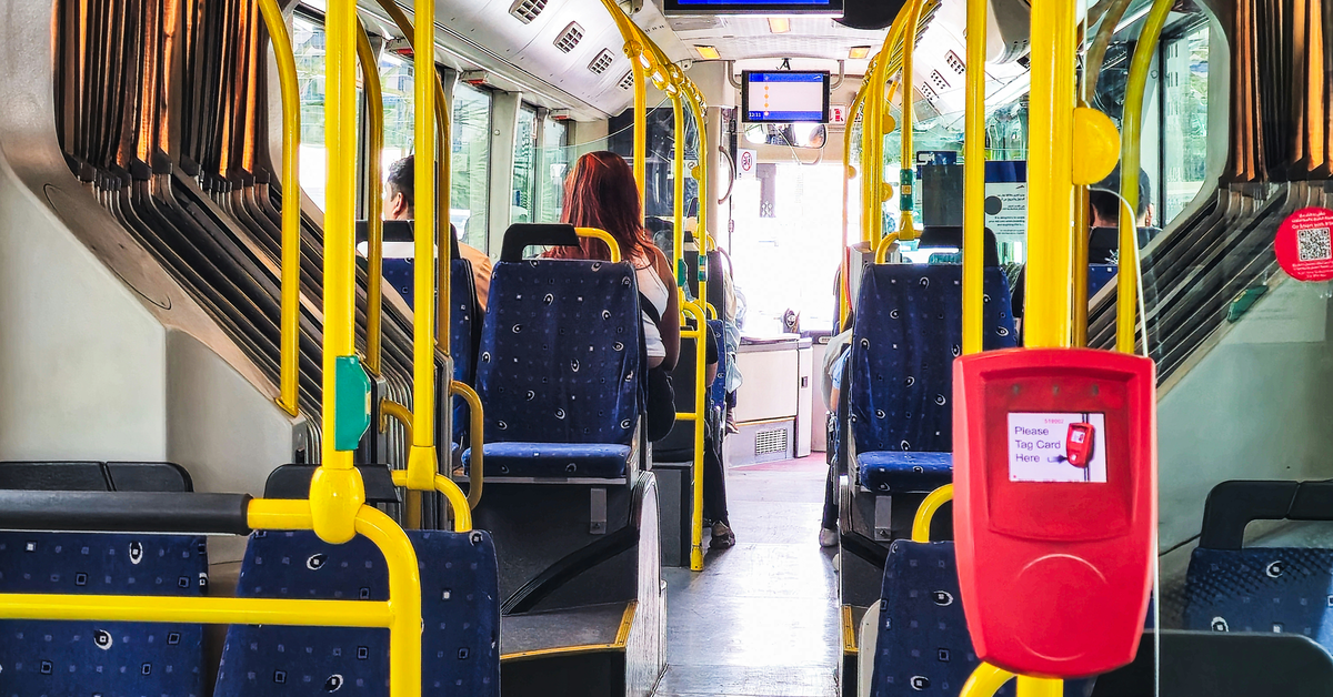 The interior of an RTA bus in Dubai, showing the seats, handrails, and passenger space